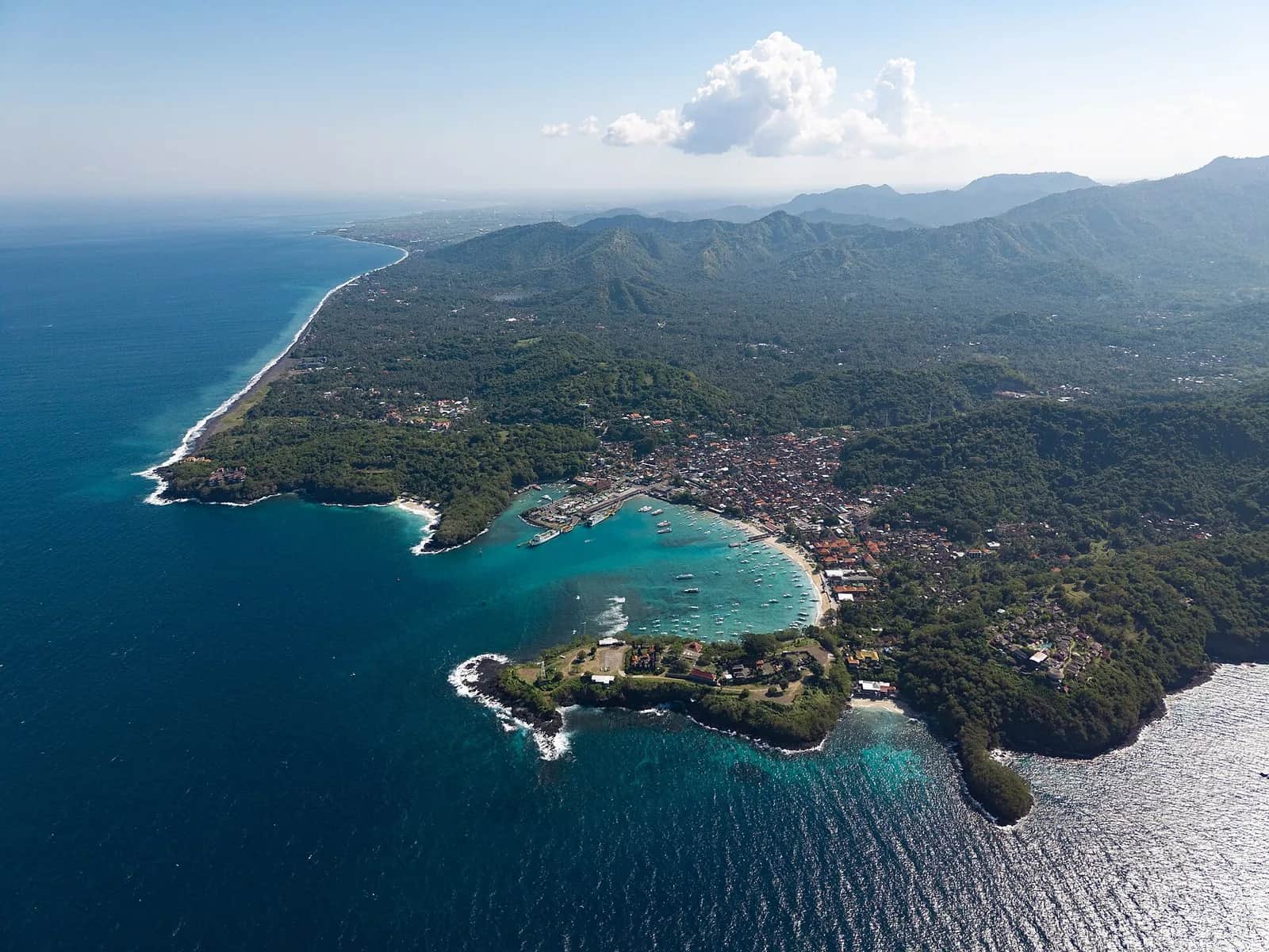 Aerial view of Padang Bai bay with turquoise water and the white sand headlands where Blue Lagoon Beach sits, east Bali