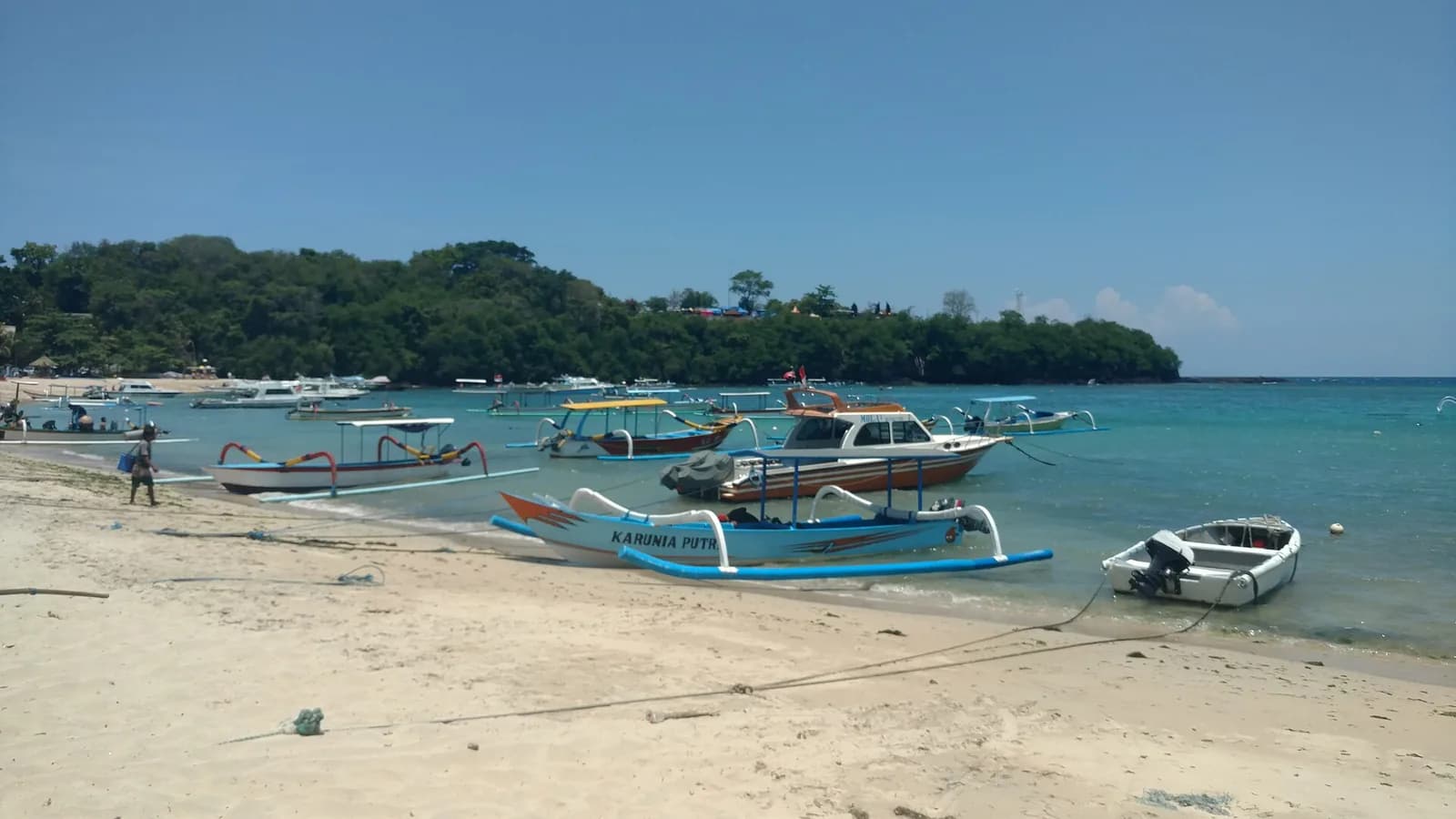 Jukung outriggers and speedboats pulled up on the main beach of Padang Bai, Bali