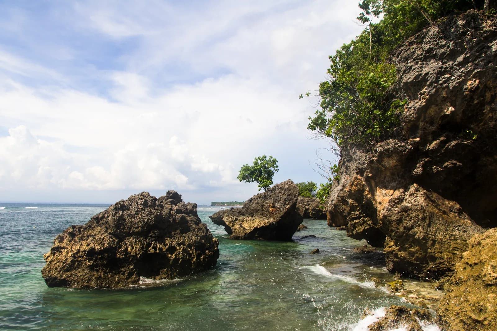 Limestone boulders and a shallow reef shelf exposed at low tide at Padang Padang, Bali