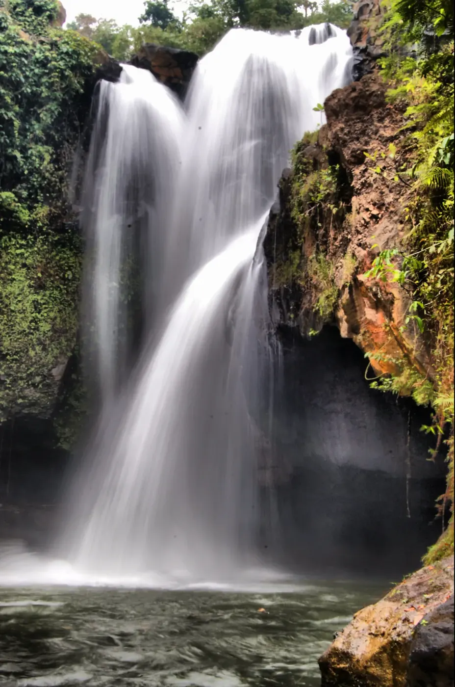 Kemenuh waterfall in Gianyar falling as a tall vertical column into a dark pool
