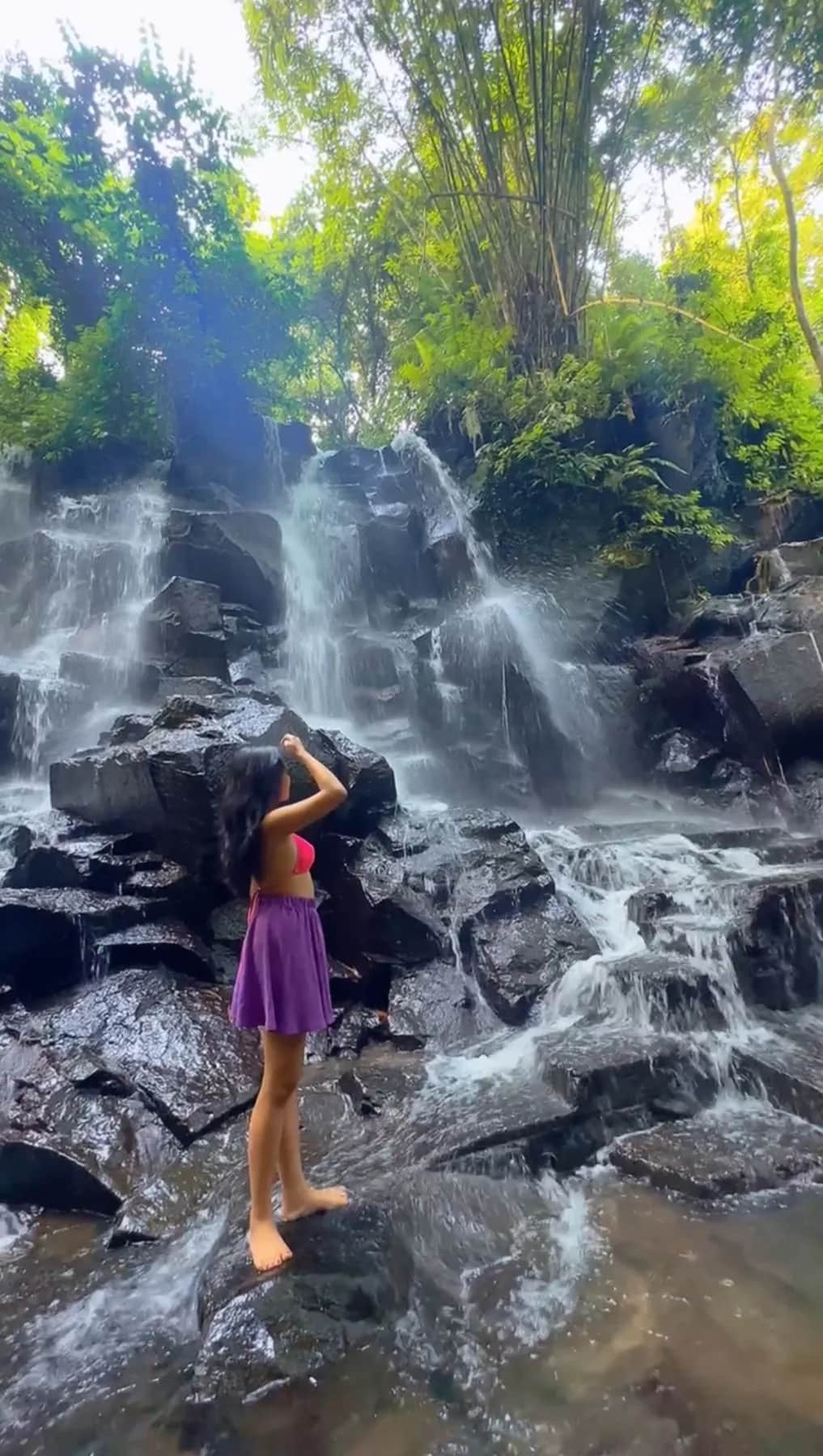 Water sheeting down the stepped rock face of Kanto Lampo waterfall, Gianyar, Bali