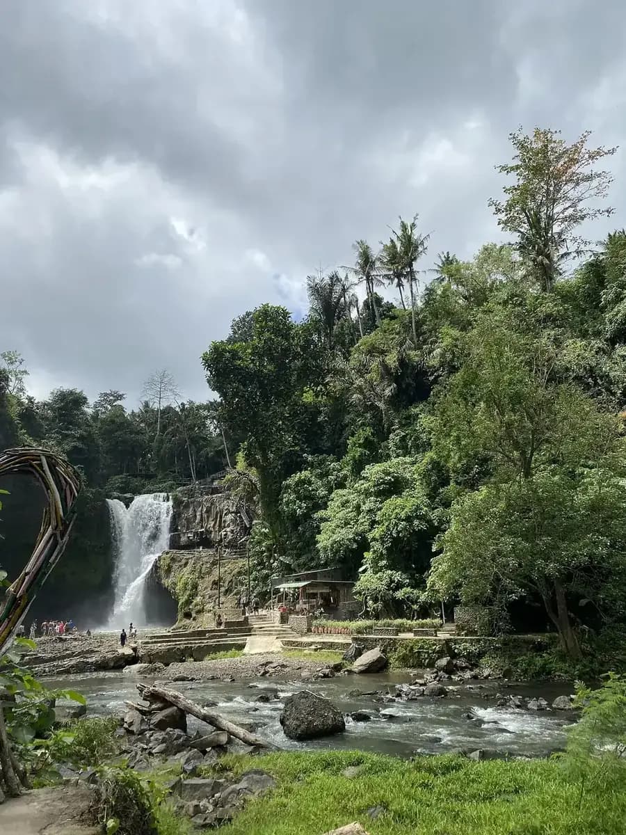 The base of Tegenungan with a photo prop in the foreground, warungs on the bank and the fall in the distance