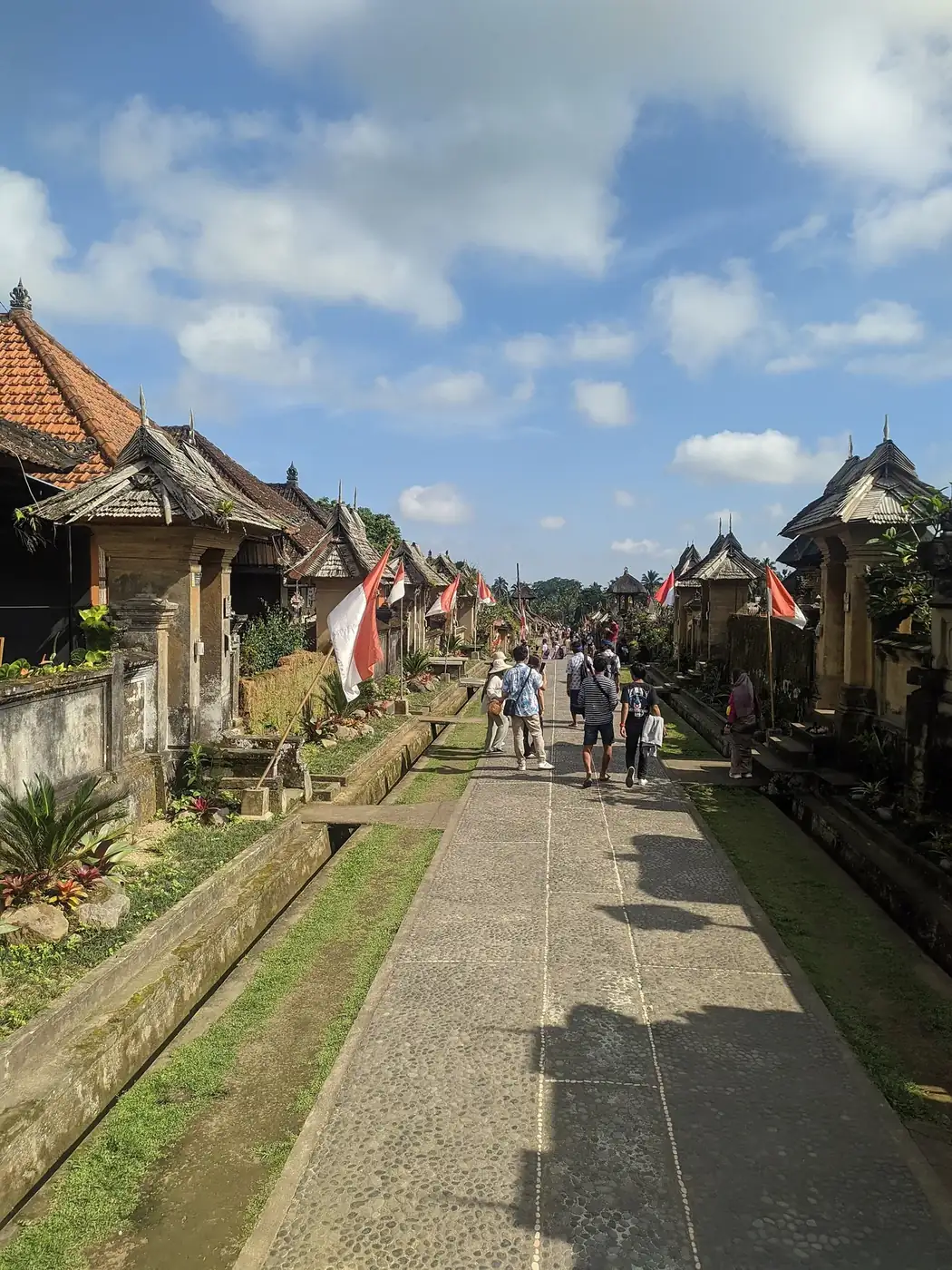 The cobbled main street of Penglipuran traditional village in Bangli, lined with gateways and thatched roofs