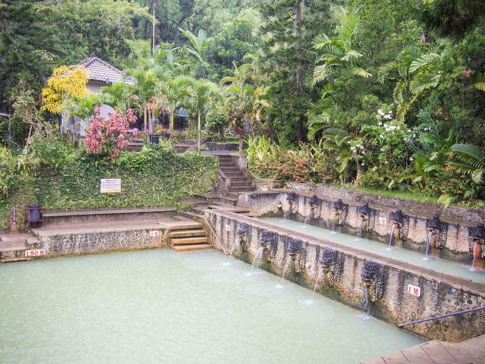 Green hot spring pools with naga-head spouts at Air Panas Banjar, near Lovina, Bali