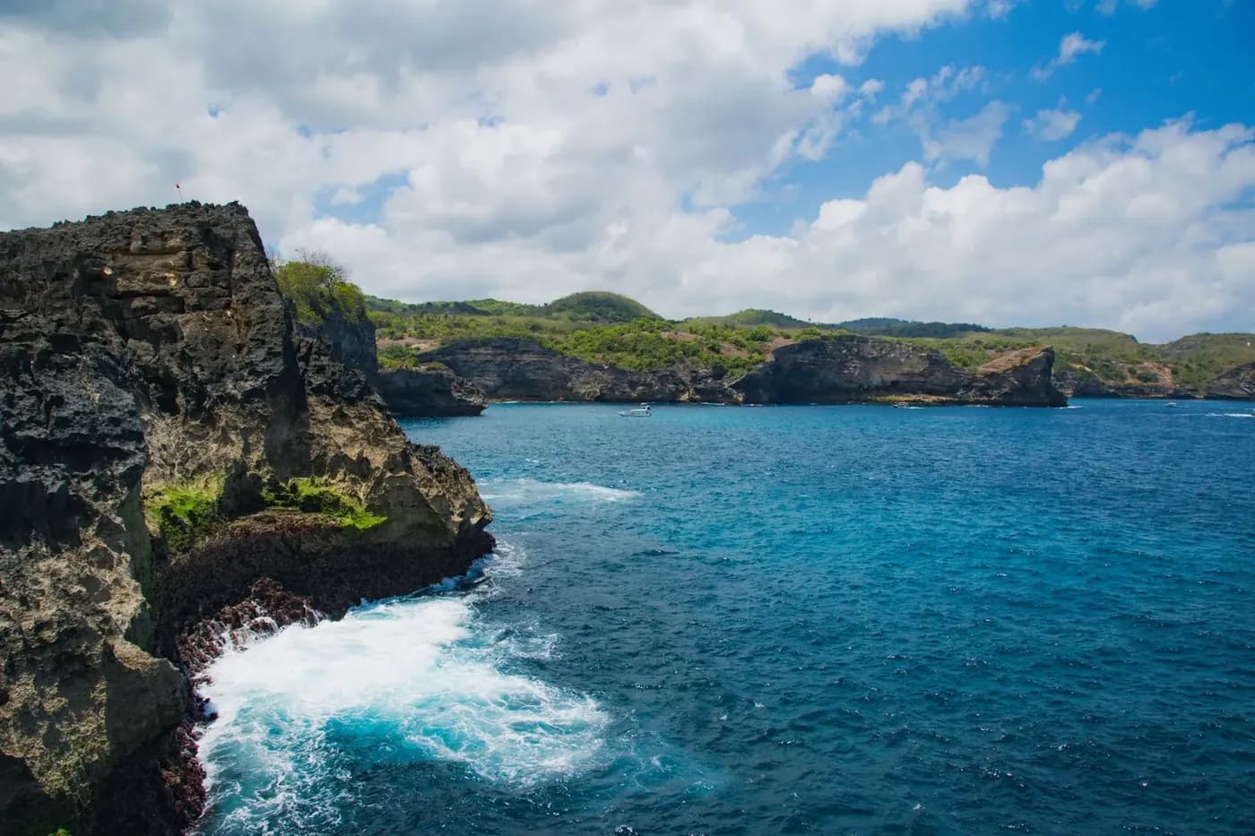 Eroded limestone cliffs and white water along the west coast of Nusa Penida near Broken Beach