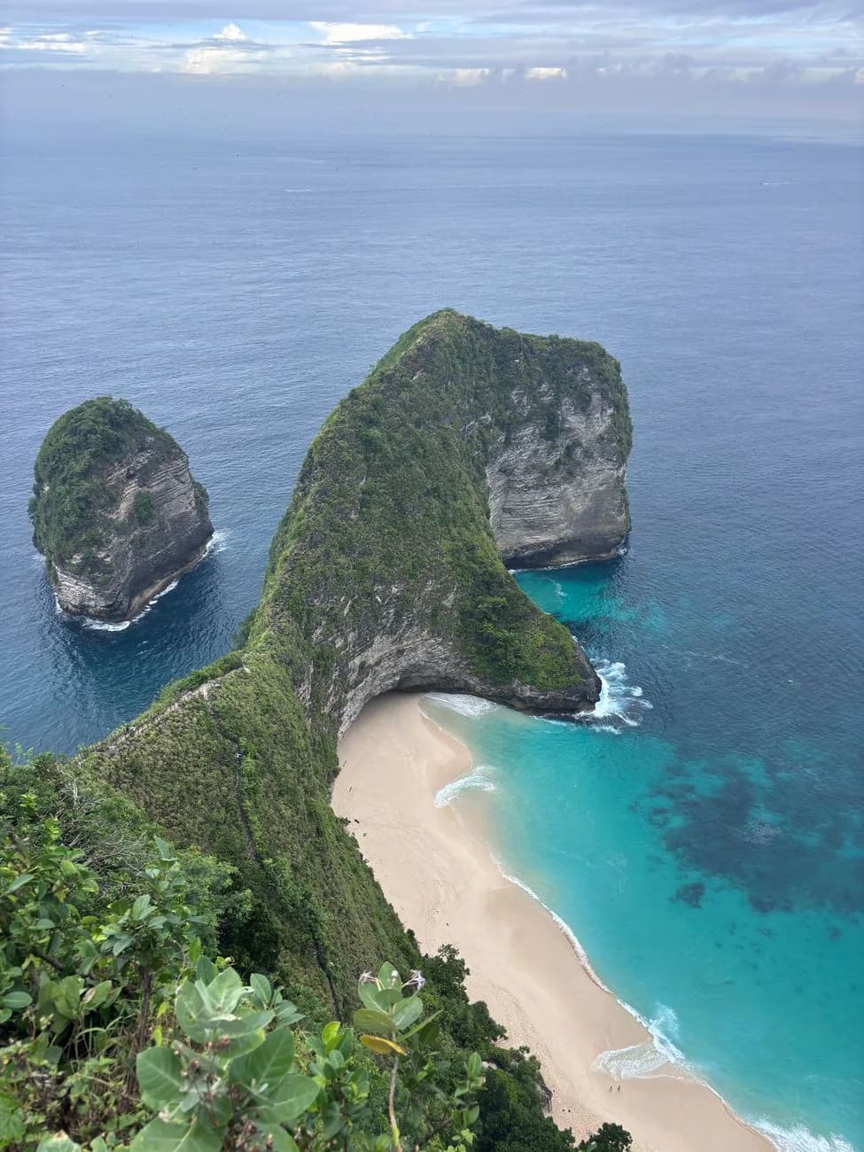 The beach and headland at Kelingking seen from the clifftop on an overcast morning, Nusa Penida