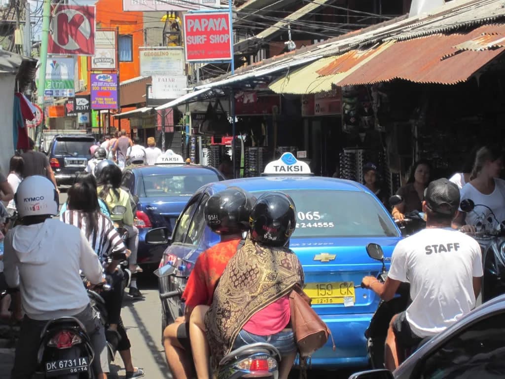 Scooters and taxis crowding a narrow back street near Kuta Beach, Bali