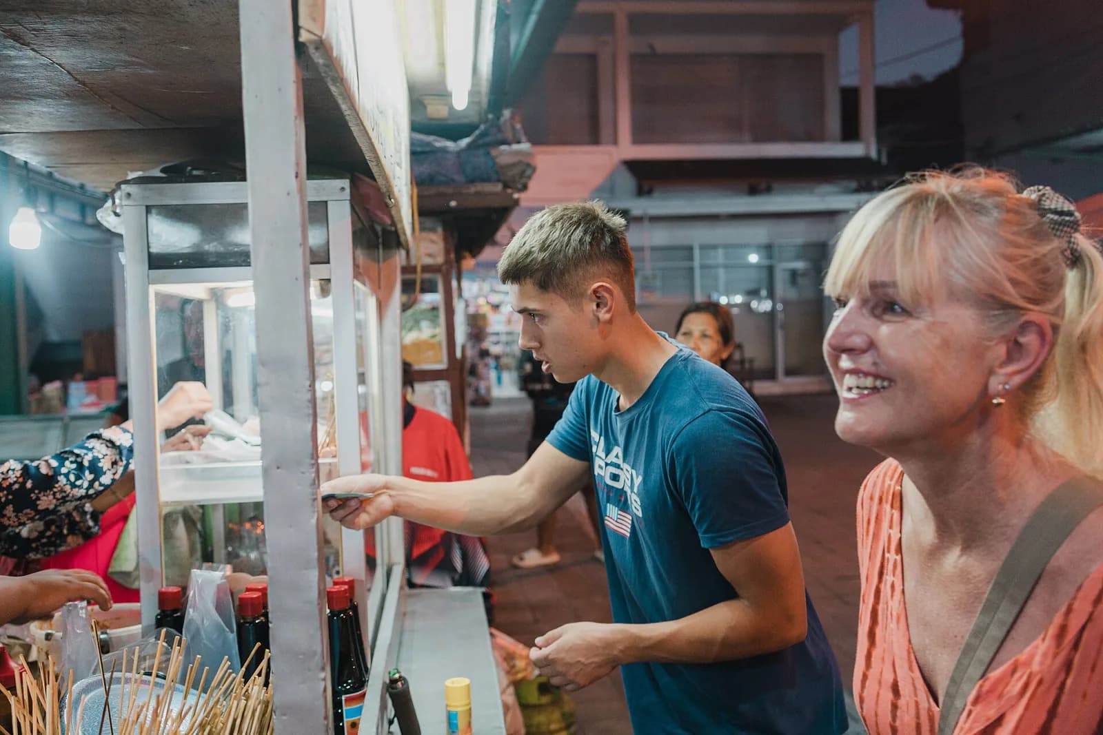 Visitors ordering from a food stall at the Sindhu Night Market (Pasar Sindu) in Sanur, Bali