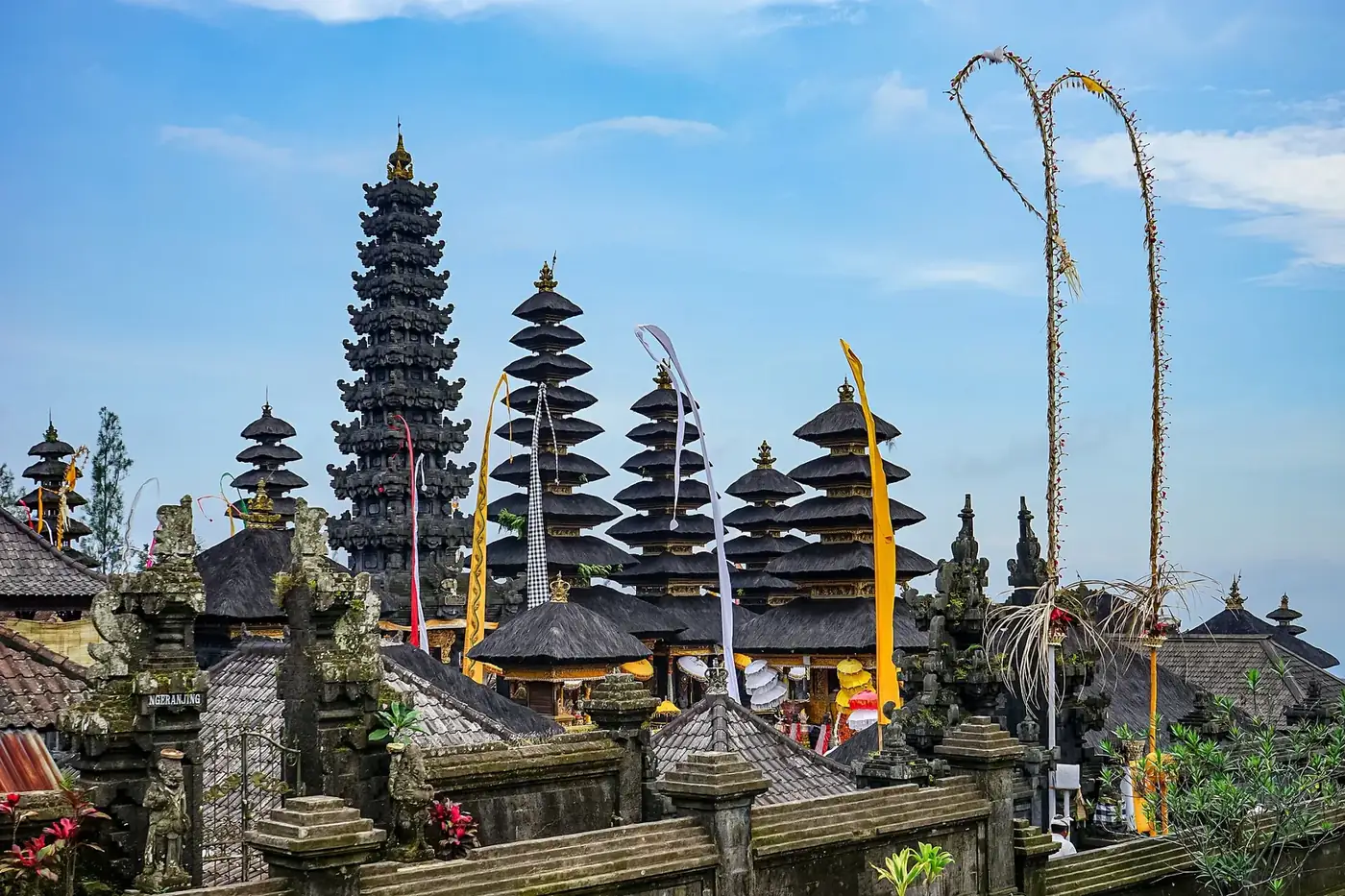 Meru towers and ceremonial penjor poles above the walls of the Besakih temple complex, Bali