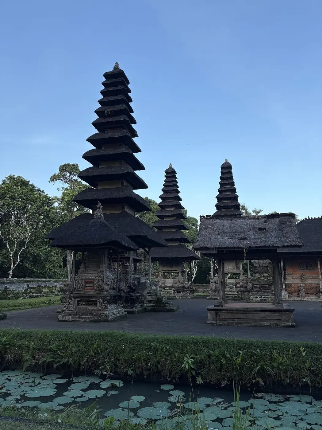 The eleven tiered meru tower at Taman Ayun rising above shrines, with the lotus filled moat below
