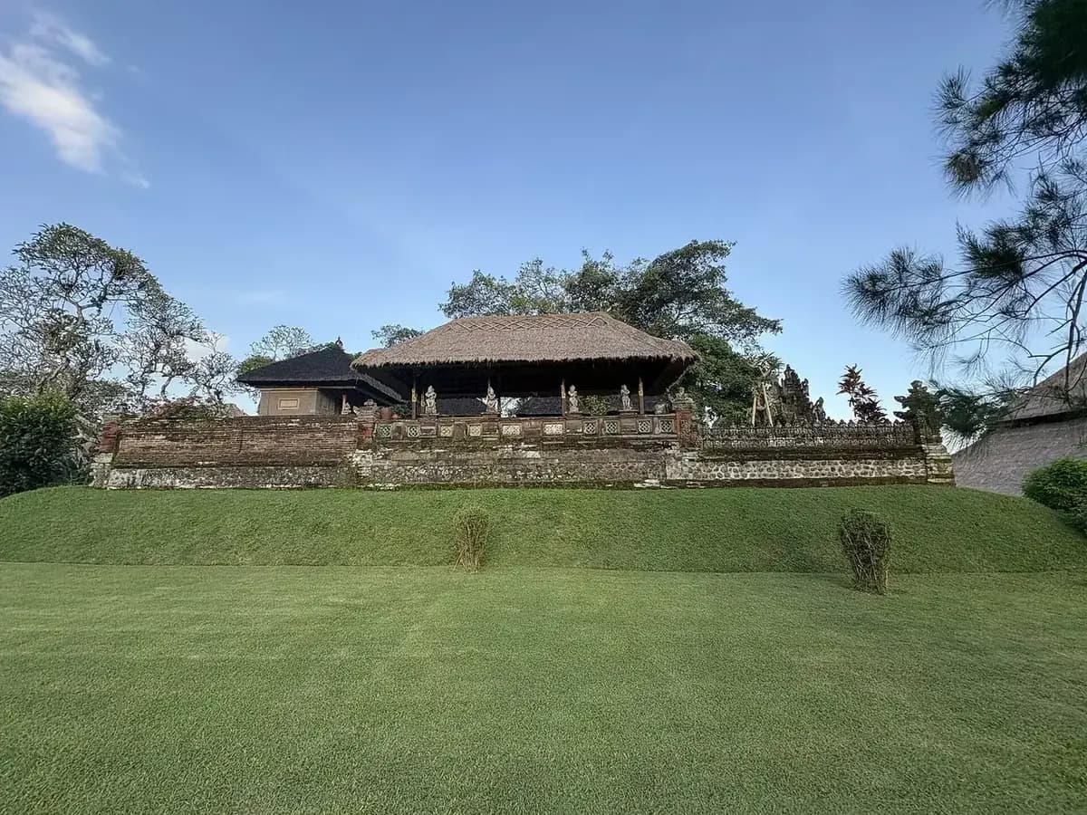 Large open thatched pavilion above a mown lawn in the outer grounds of Taman Ayun, Mengwi