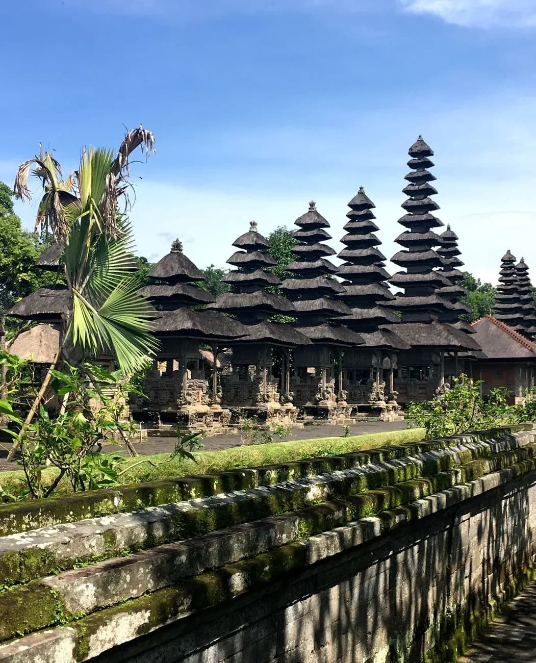 Row of meru towers at Taman Ayun temple seen across the moat wall, Mengwi, Bali