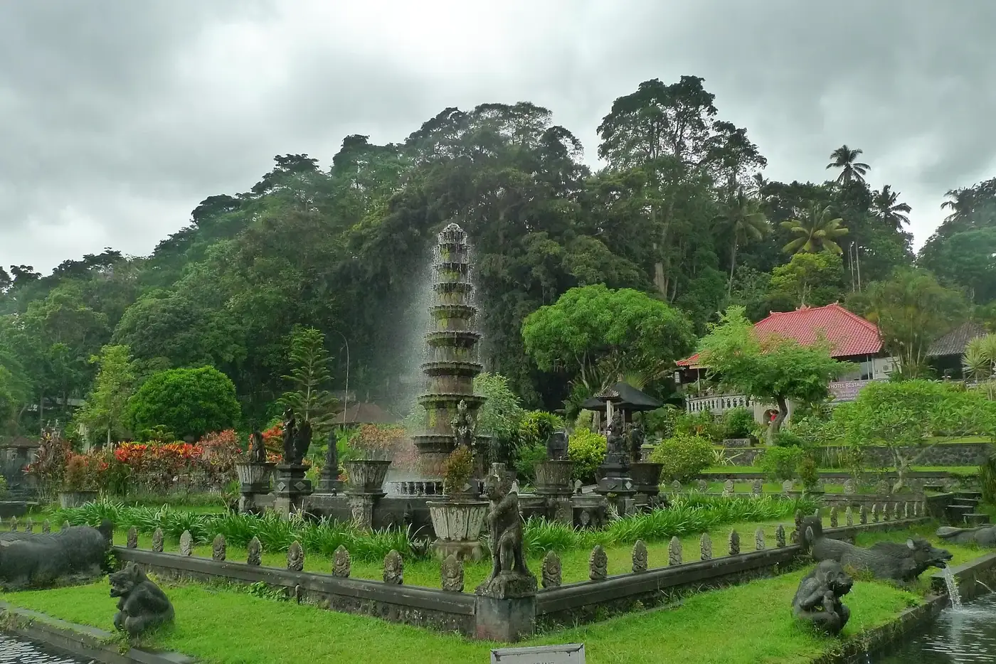 The gardens of Tirta Gangga seen from the entrance, with the tiered fountain spraying in the middle of the ponds