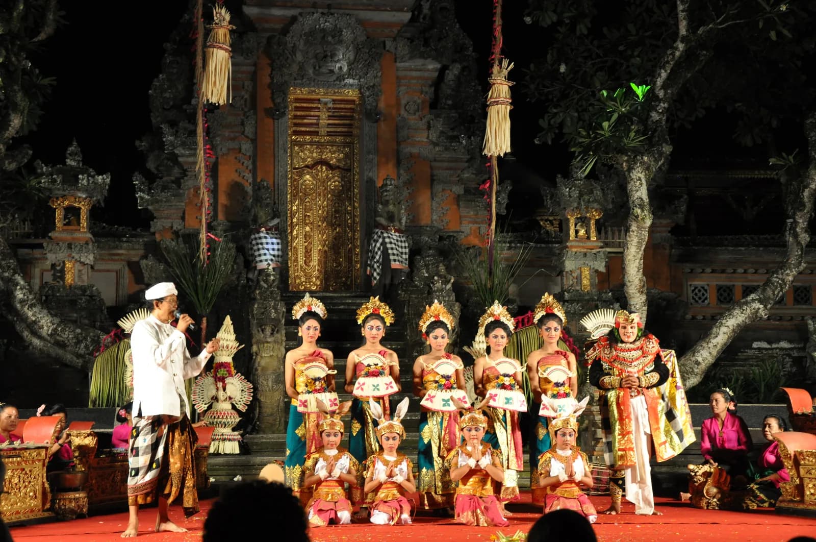 Dancers of the Chandrawati Ladies Orchestra troupe in gold costumes on the evening stage at Pura Taman Saraswati, Ubud