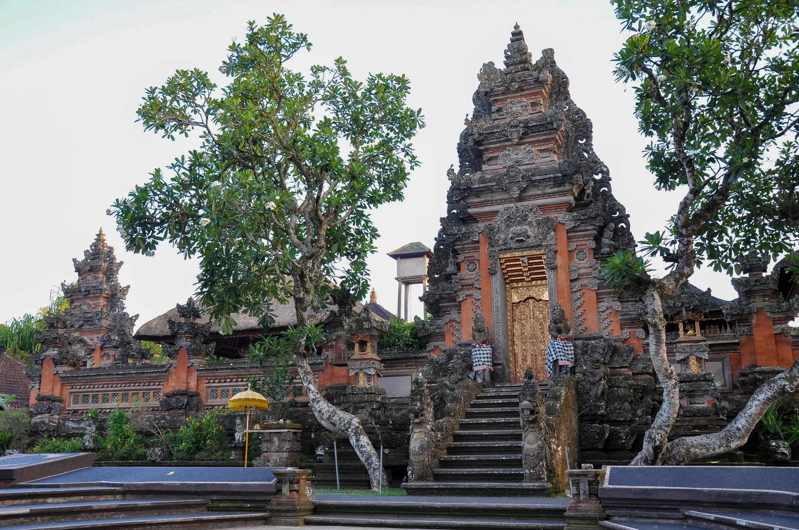 The carved red-brick kori agung gates of Pura Taman Saraswati with steps leading up to the inner temple, Ubud, Bali