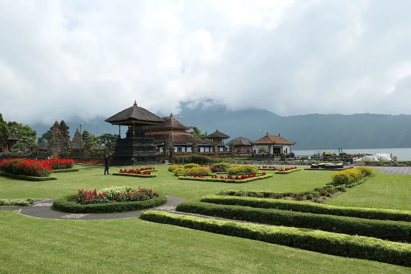 The clipped lawns, hedges and flowerbeds of the garden park at Ulun Danu Beratan with cloud on the mountain behind