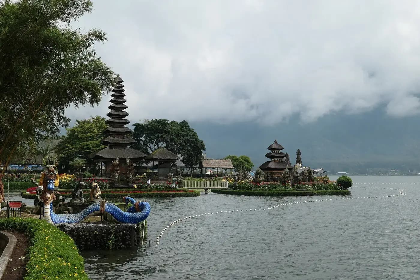 The blue naga fountain in the gardens of Ulun Danu Beratan with both meru shrines behind on the lake