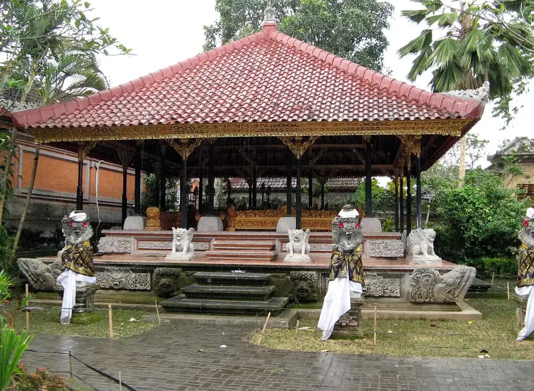 The raised pavilion used as a stage at Ubud Palace, empty in daylight with stone guardians in front