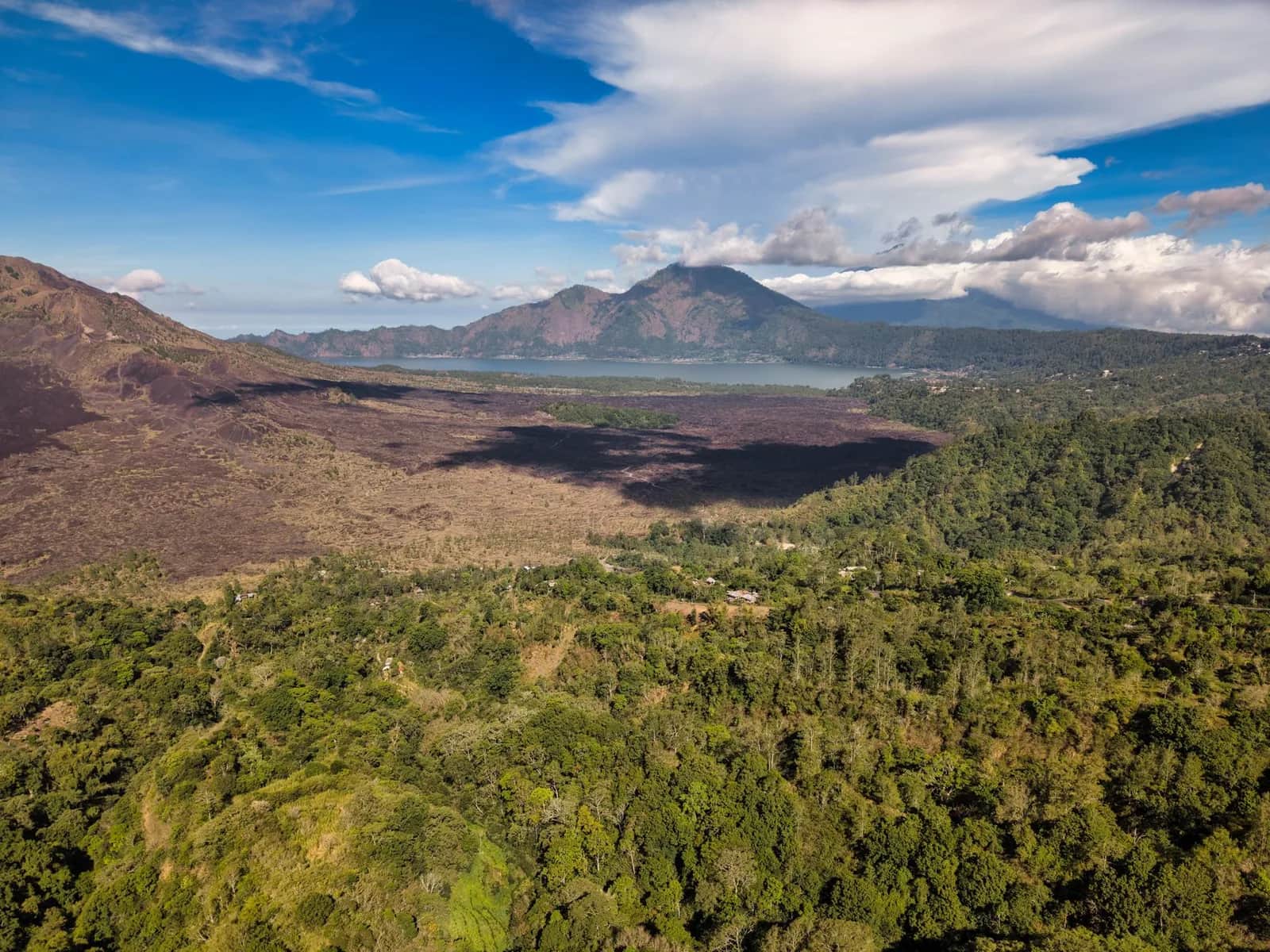 The Batur caldera from the Kintamani rim road, with the volcanic cone, its black lava field and Lake Batur behind it, Bali