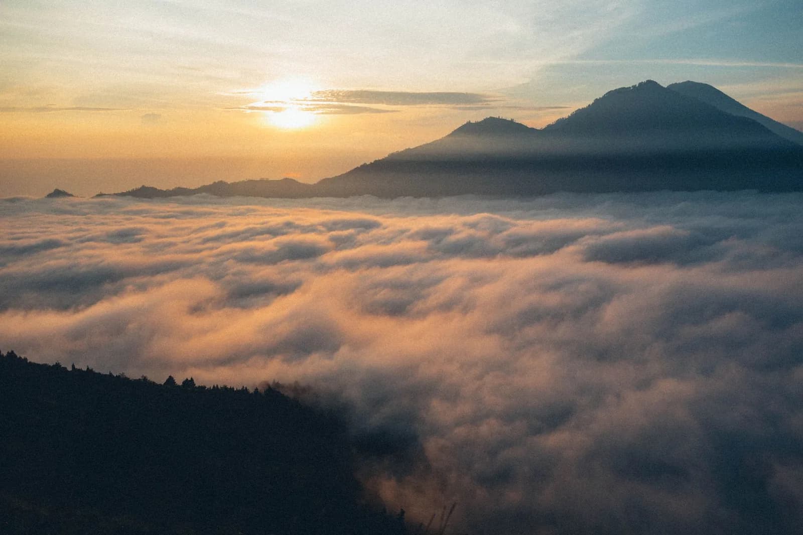 Sunrise over a sea of cloud from the summit rim of Mount Batur, Kintamani, Bali